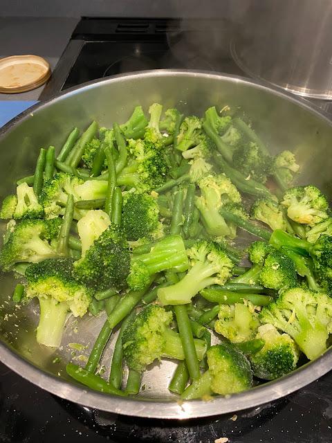 a wide skillet with broccoli and green beans, vegan