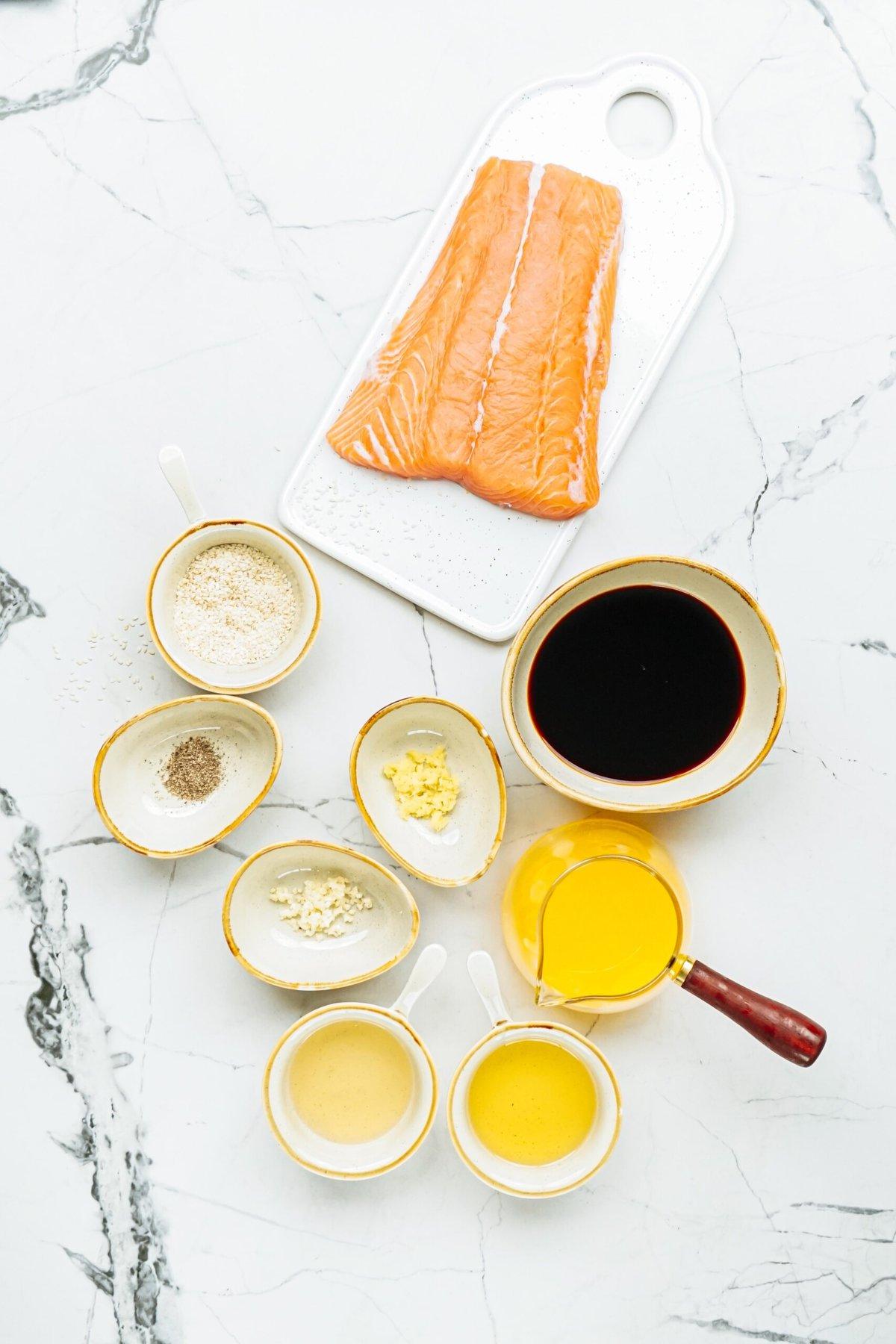Ingredients for a salmon dish on a elegant marble countertop.