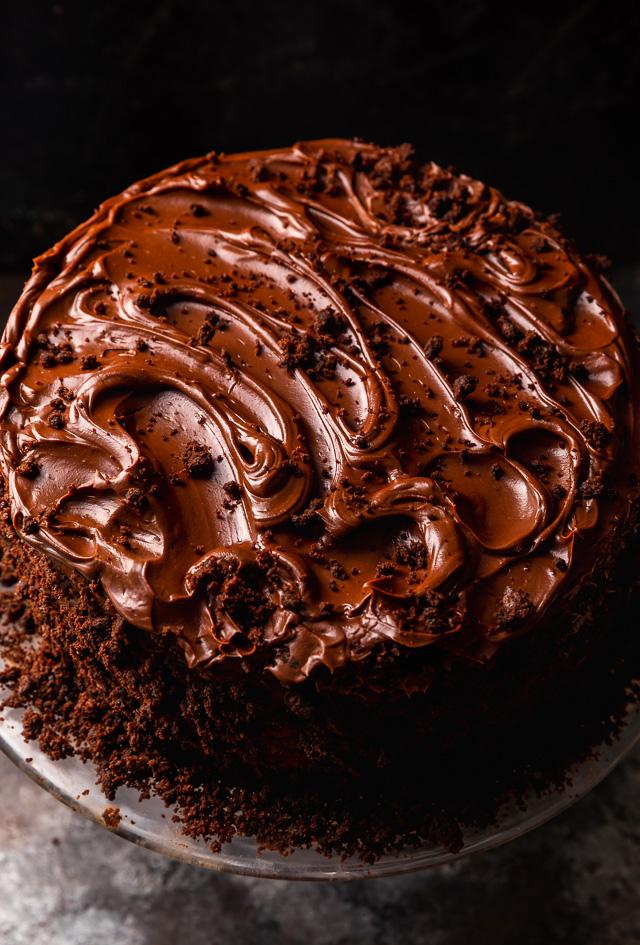Whole devil's food cake covered in chocolate frosting and cake crumbs.