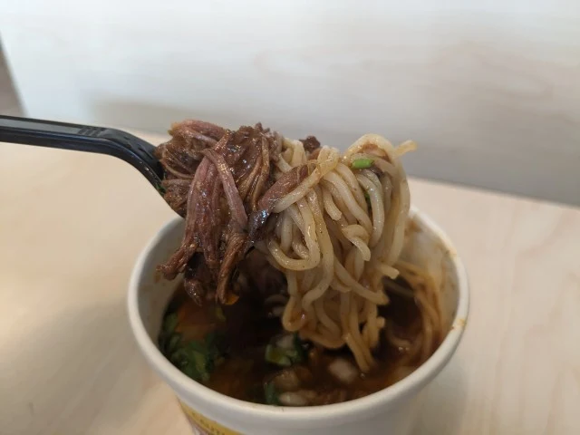 A forkful of Del Taco's Birria Ramen.