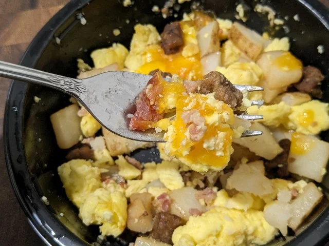 A forkful of Aldi's Breakfast Best Meat Lovers Breakfast Bowl.