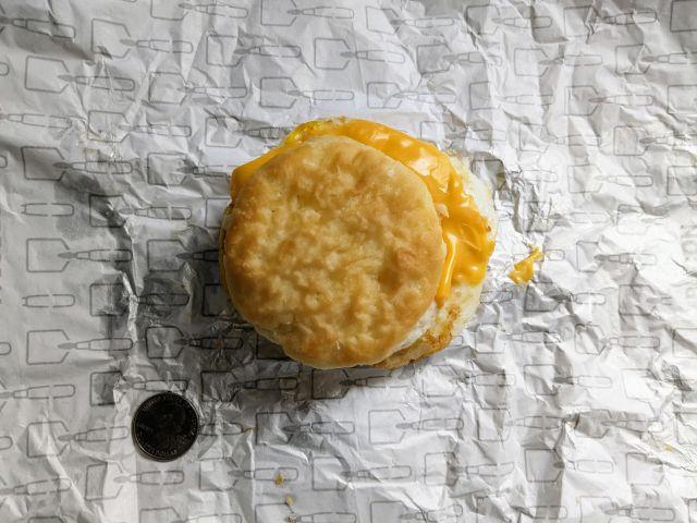 Wendy's Egg & Cheese Biscuit next to a quarter.