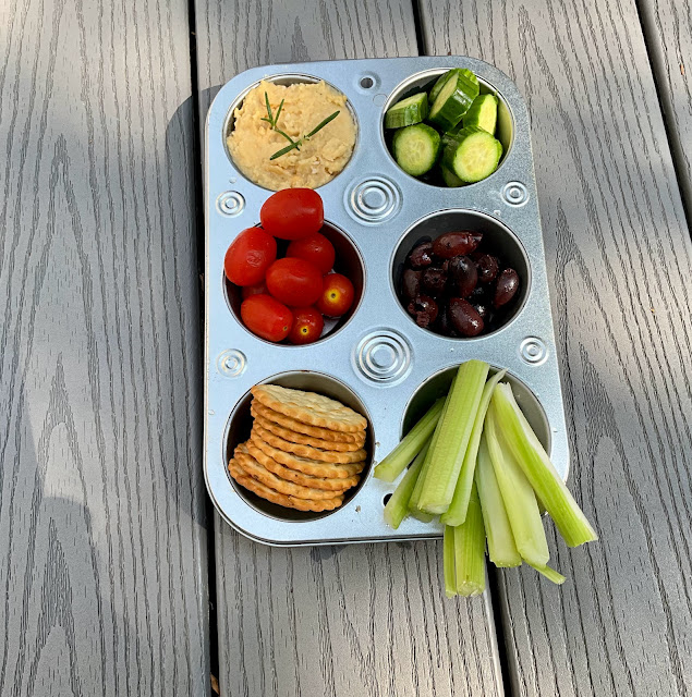 muffin tin filled with vegetables and hummus