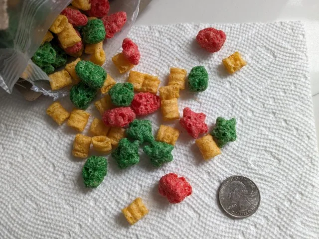 Close-up of Cap'n Crunch's Christmas Crunch Cereal next to a quarter.