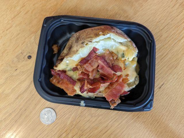 Wendy's Bacon Queso Baked Potato next to a quarter.