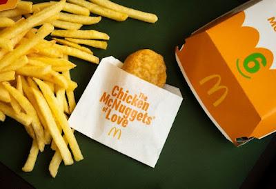 McDonald's single Chicken McNugget next to fries and a box of Chicken McNuggets.