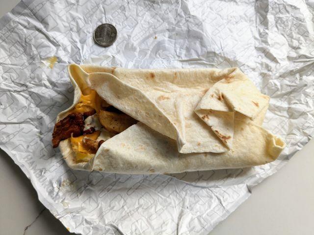 Wendy's Breakfast Burrito next to a quarter.