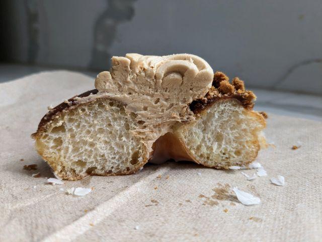 Cross-section of Krispy Kreme's Biscoff Chocolate Iced Cookie Butter Crunch Donut.