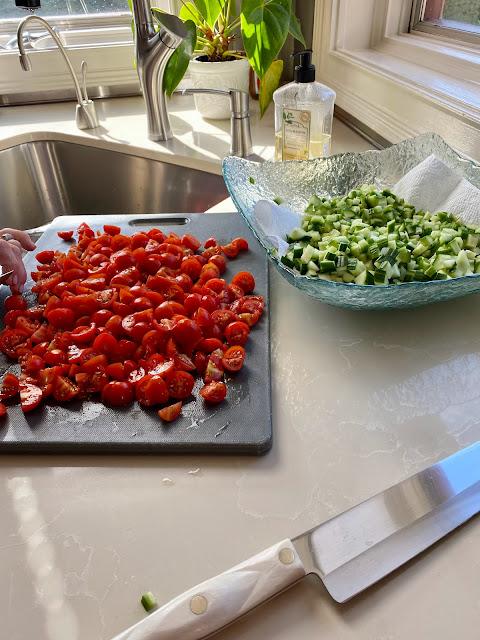 Platter of chopped cherry tomatoes and another of chopped cucumber