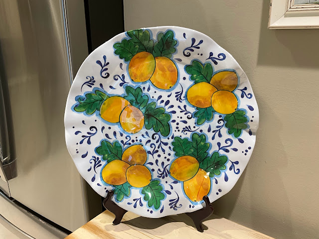 Large white platter with lemons and green leaves