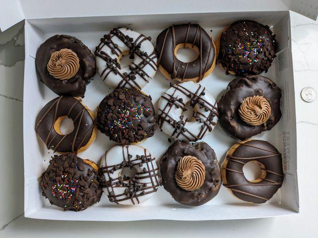 A dozen Krispy Kreme Chocomania Donuts in a box.