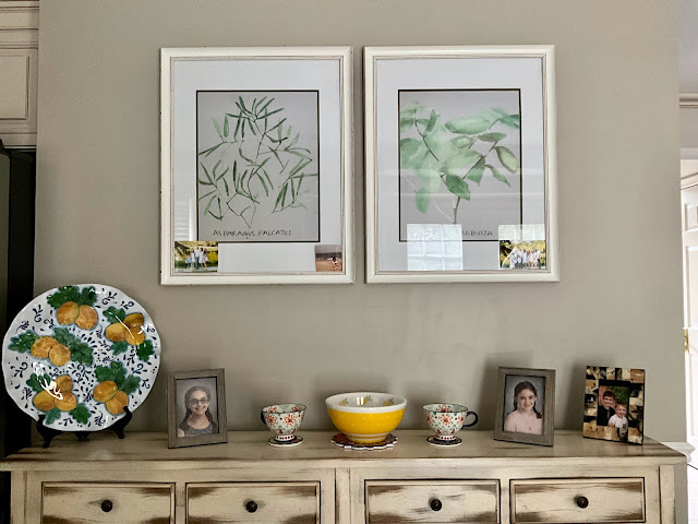 console table with photos and platters displayed