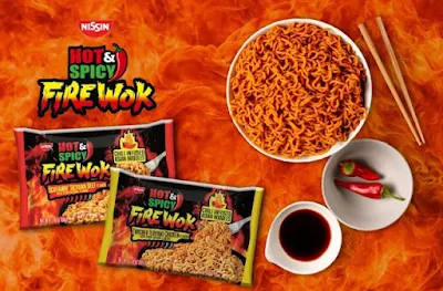 Packets of Hot & Spicy Fire Wok ramen next to a prepared bowl of noodles.