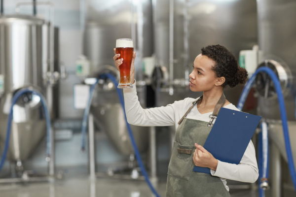 woman inspecting beer | congeners in alcohol