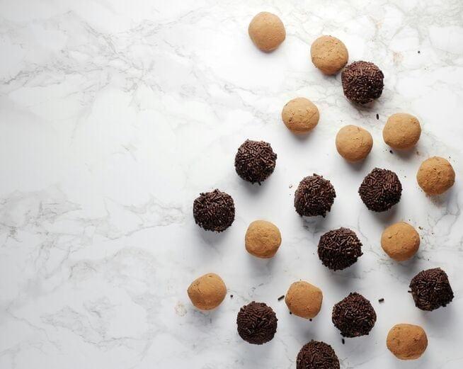 Date-filled protein balls and truffles on a marble worktop