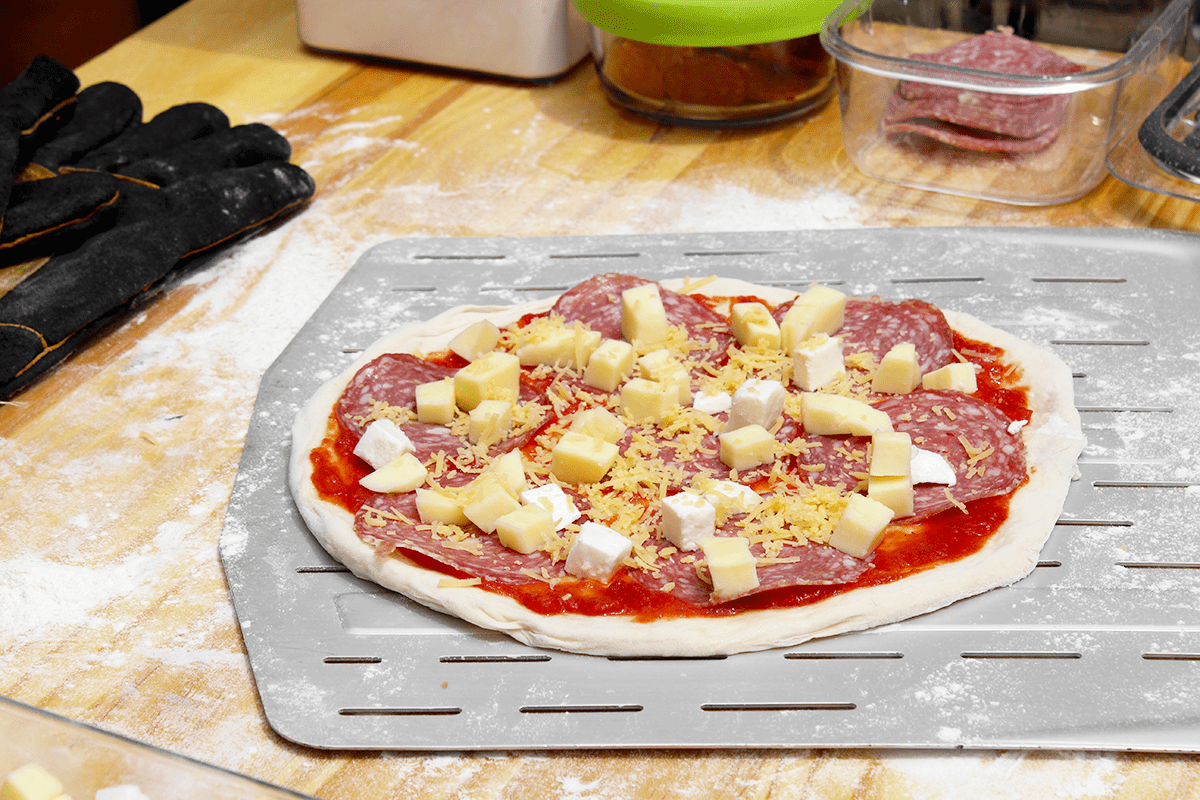 pizza dough topped and ready for the pizza oven