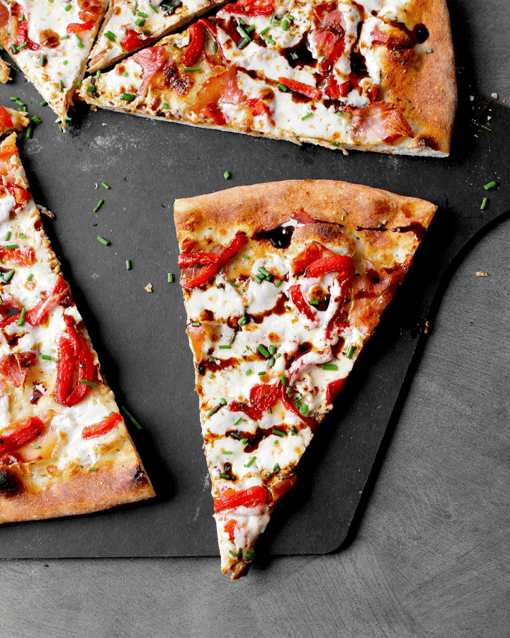 vertical shot of prosciutto pizza slice