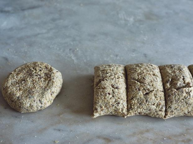 bread dough rolled out on counter and cut into portions
