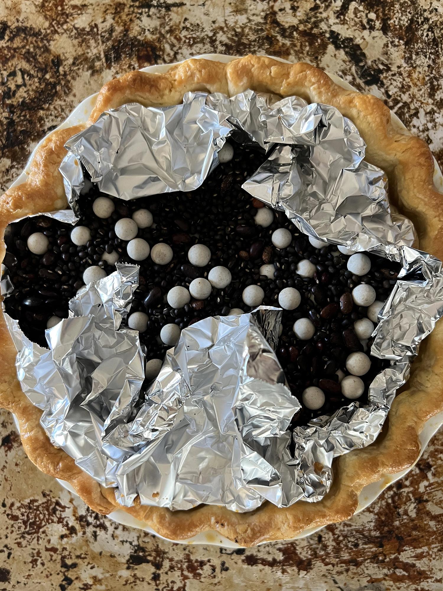 a pie crust after blind baking with pie weights and dried beans