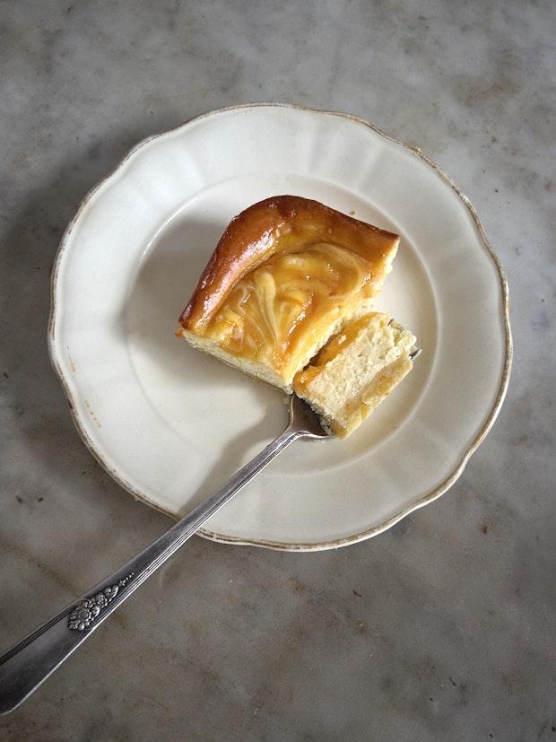 slice of a cheesecake bar on a small plate with a fork