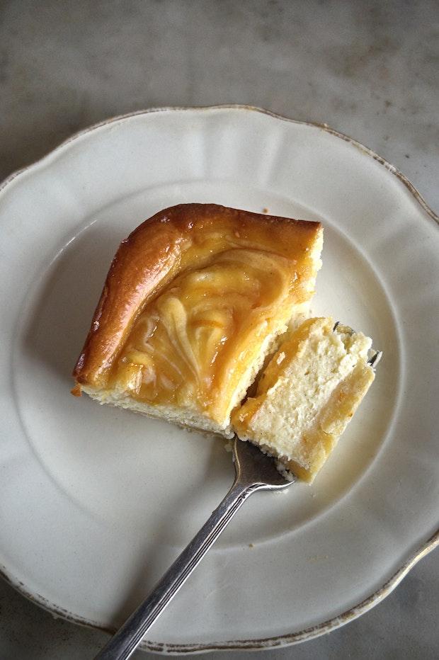 slice of a cheesecake bar on a small plate with a fork