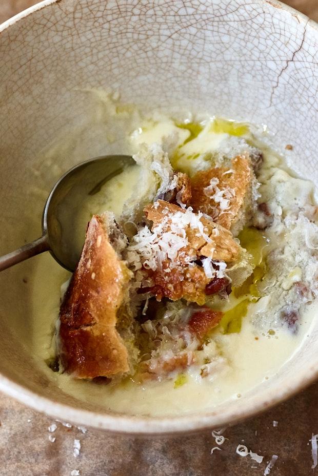 garlic soup in a bowl with toasted baguette