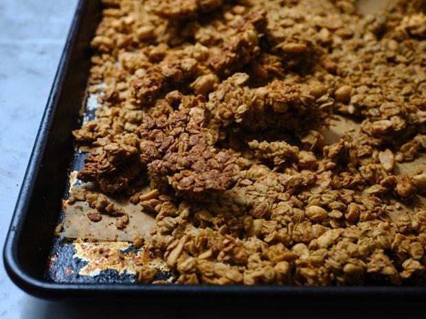 peanut butter granola cooling on a baking sheet