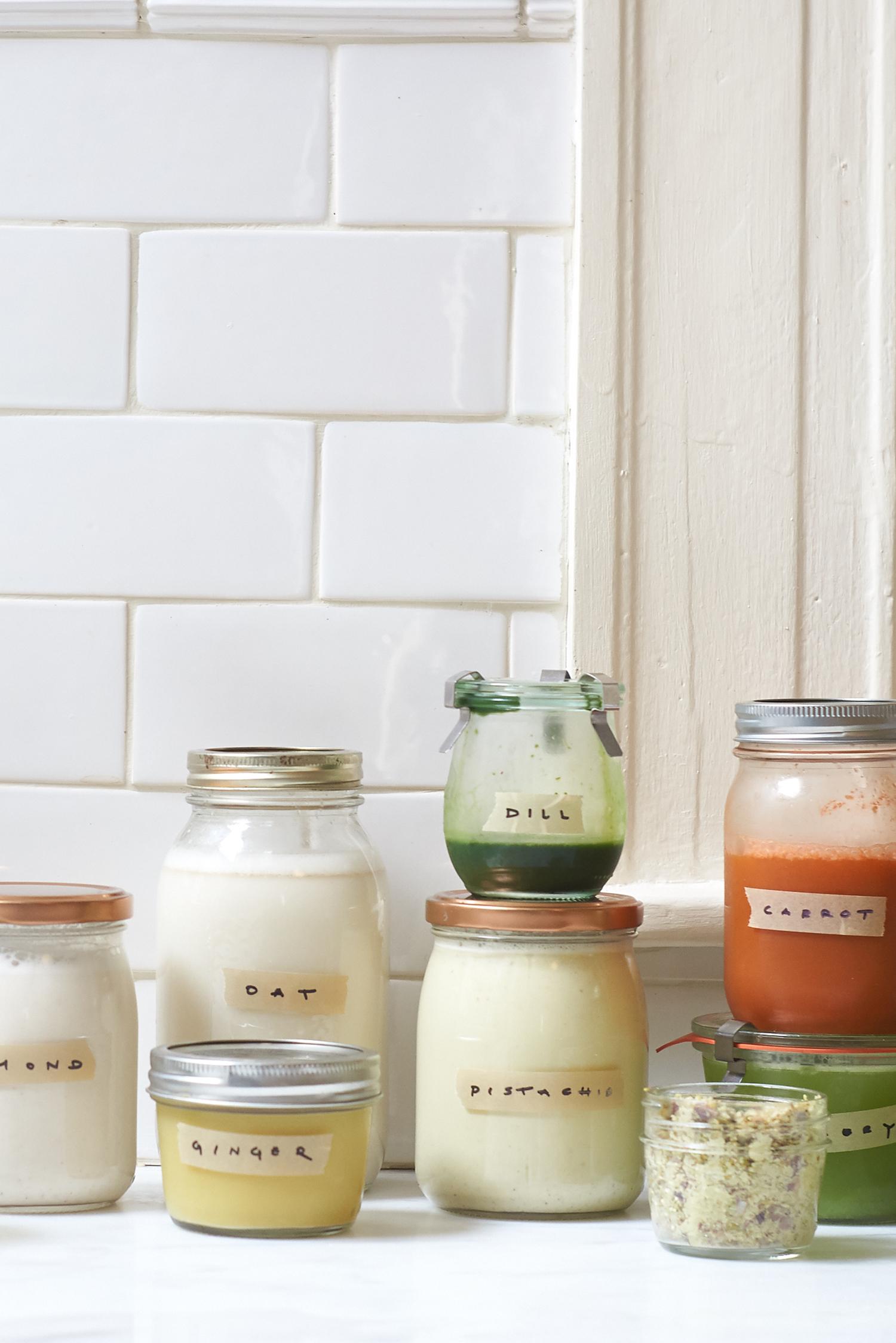 A kitchen counter after a juicing session with jars filled with different juices