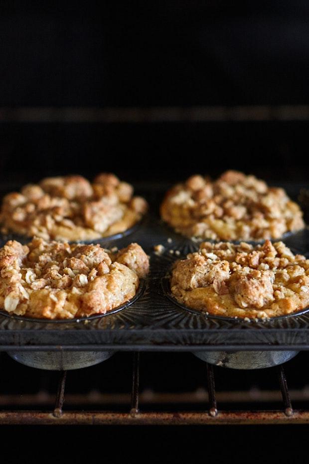 side view of oatmeal muffins baking in a muffin tin