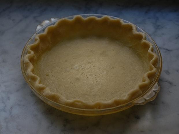 an all-butter pie crust ready to be filled and baked into pumpkin pie