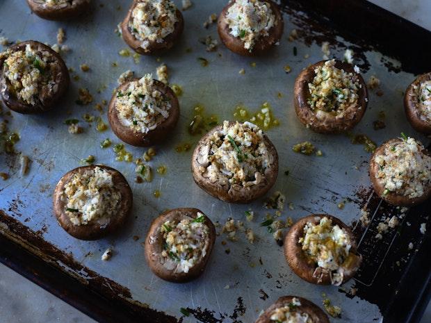 stuffed mushrooms arranged on a baking sheet prior to being place in an oven