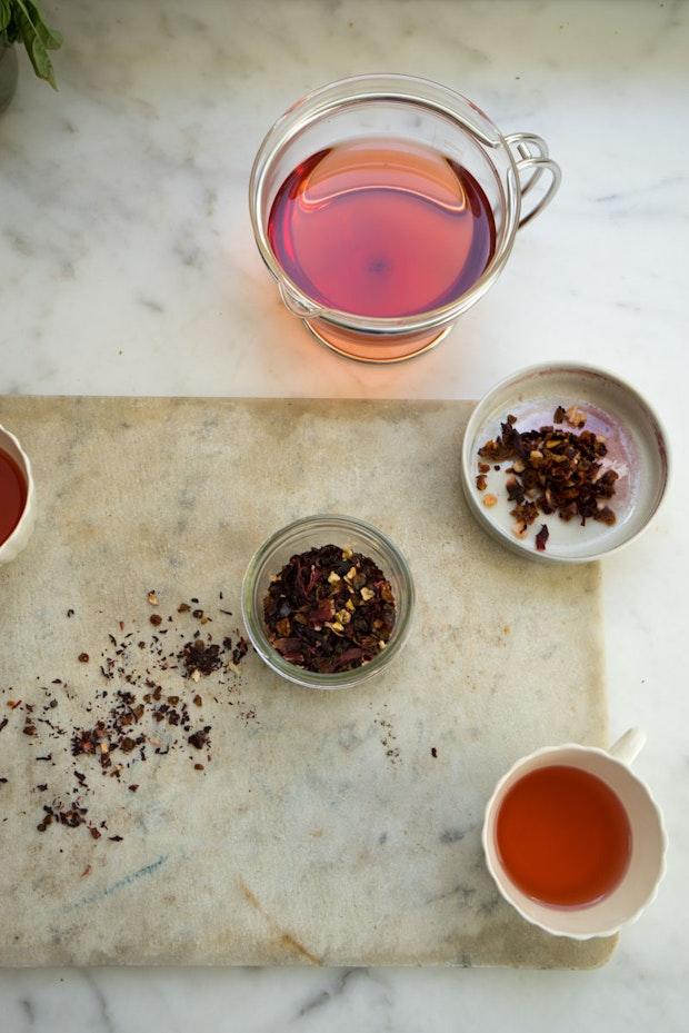 ingredients to make vitamin c tea on a counter plus a glass teapot