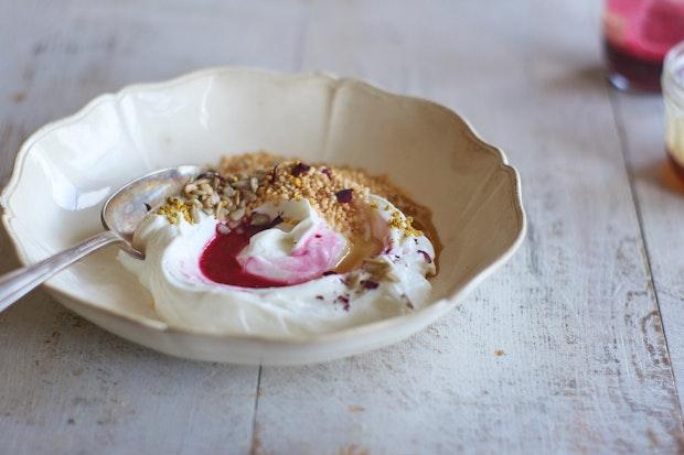 yogurt bowl topped with pomegranate juice and honey