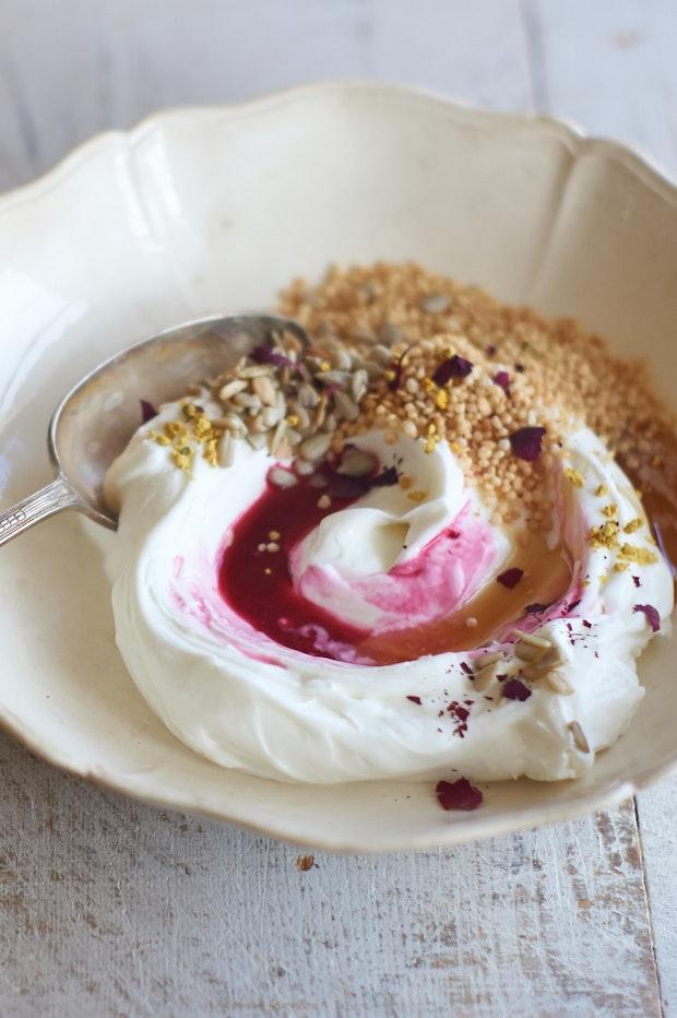 yogurt bowl topped with pomegranate juice and honey