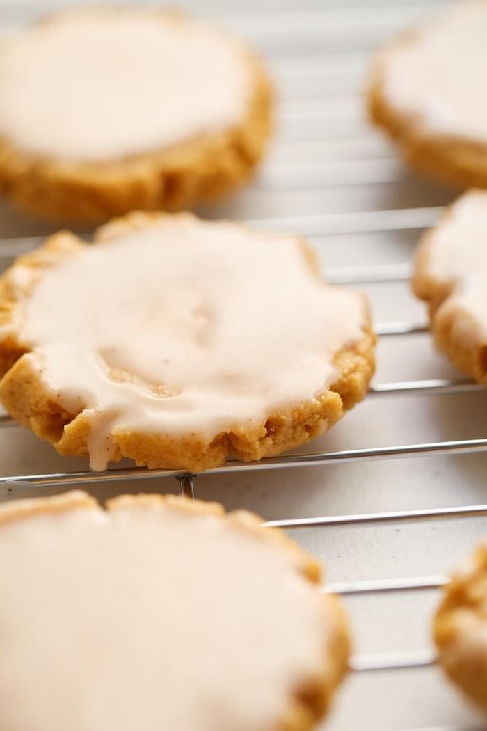 glazed pumpkin sugar cookies on a cooling wrack