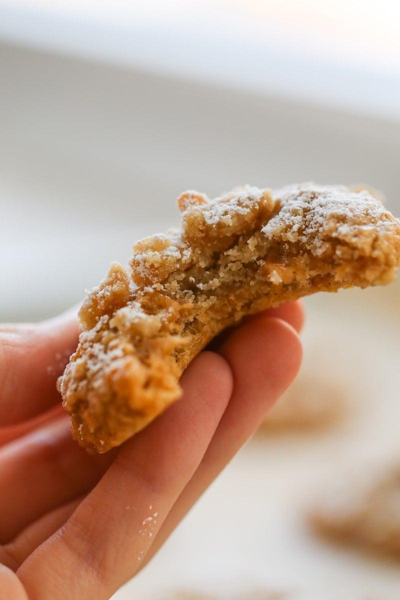 hand holding a sweet potato cookie with a bite taken out it