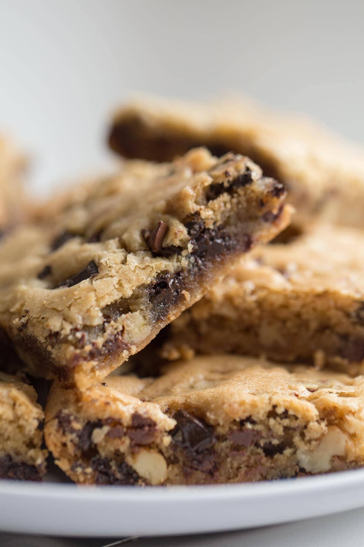 Chocolate Chip Cookie Bars stacked on top of one another all on a white plate