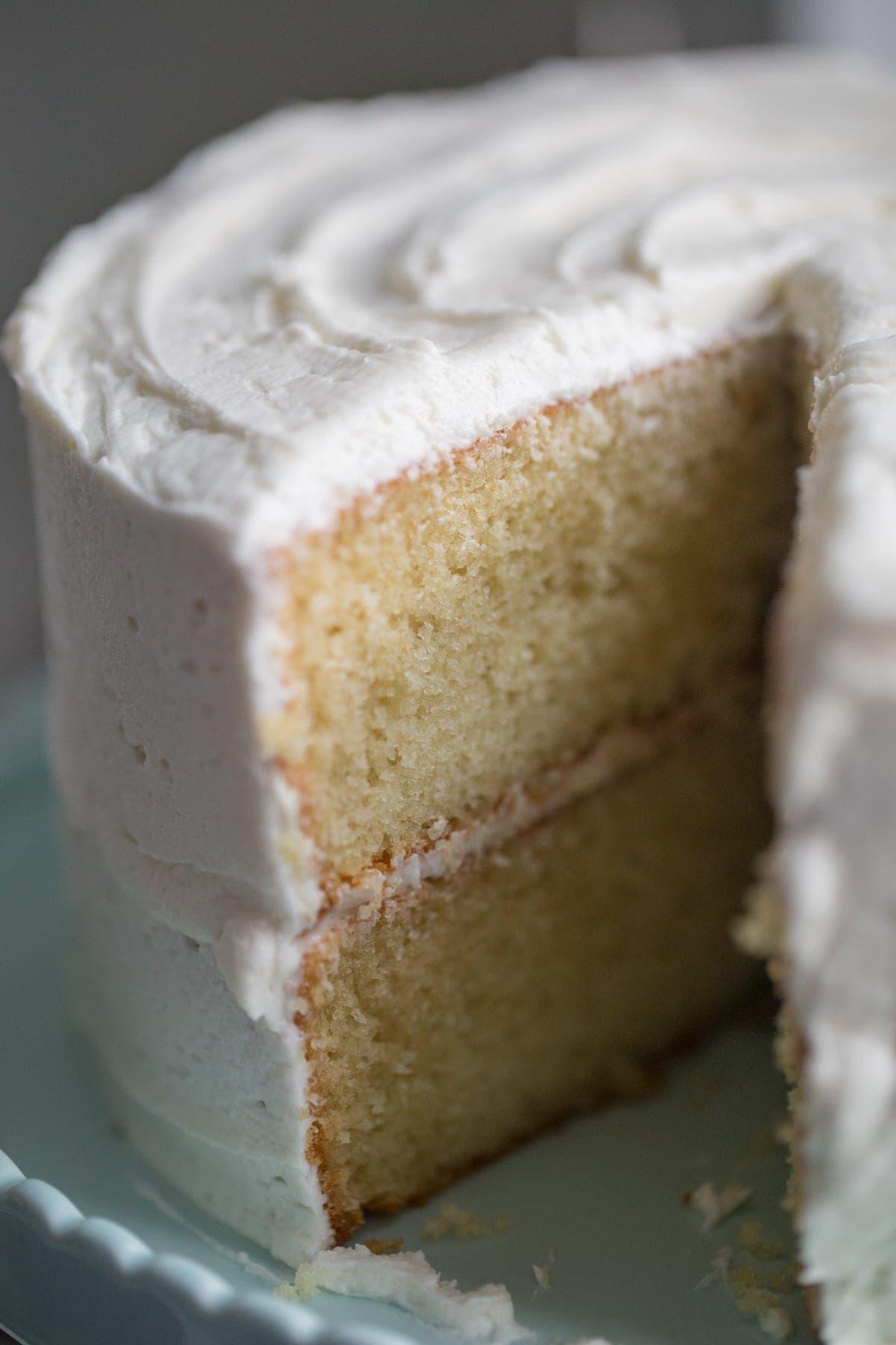 whole vanilla cake with slice removed