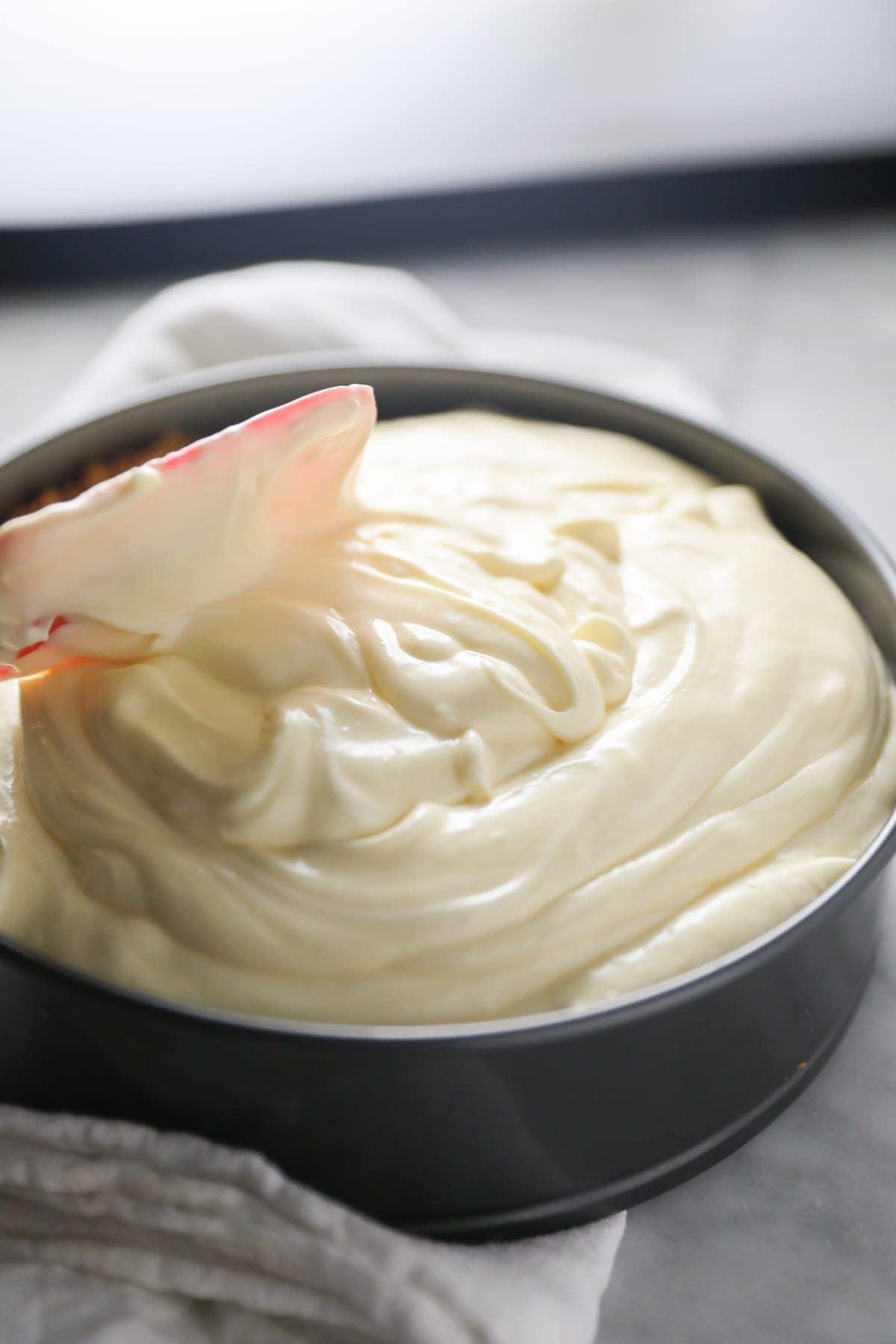 smoothing cheesecake batter into pan