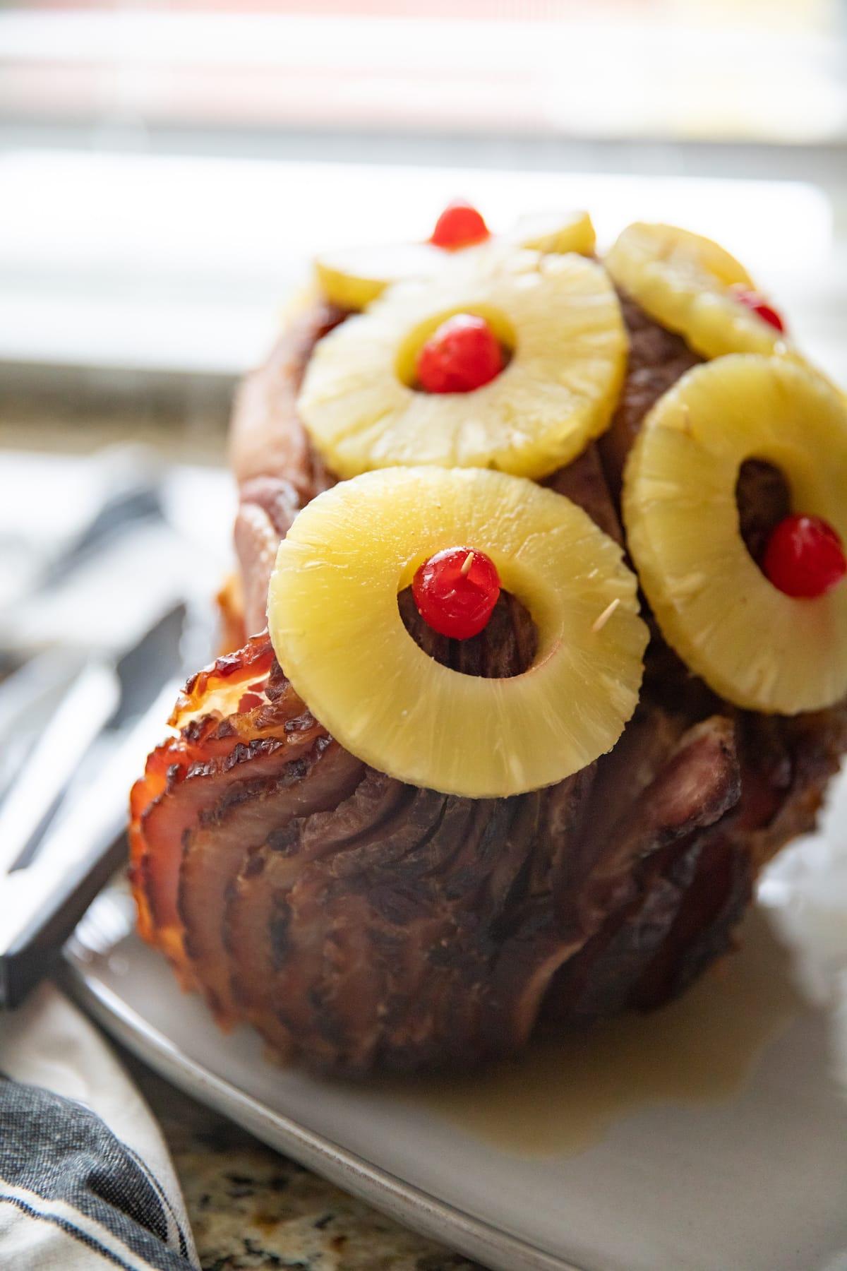 whole pineapple glazed ham on platter