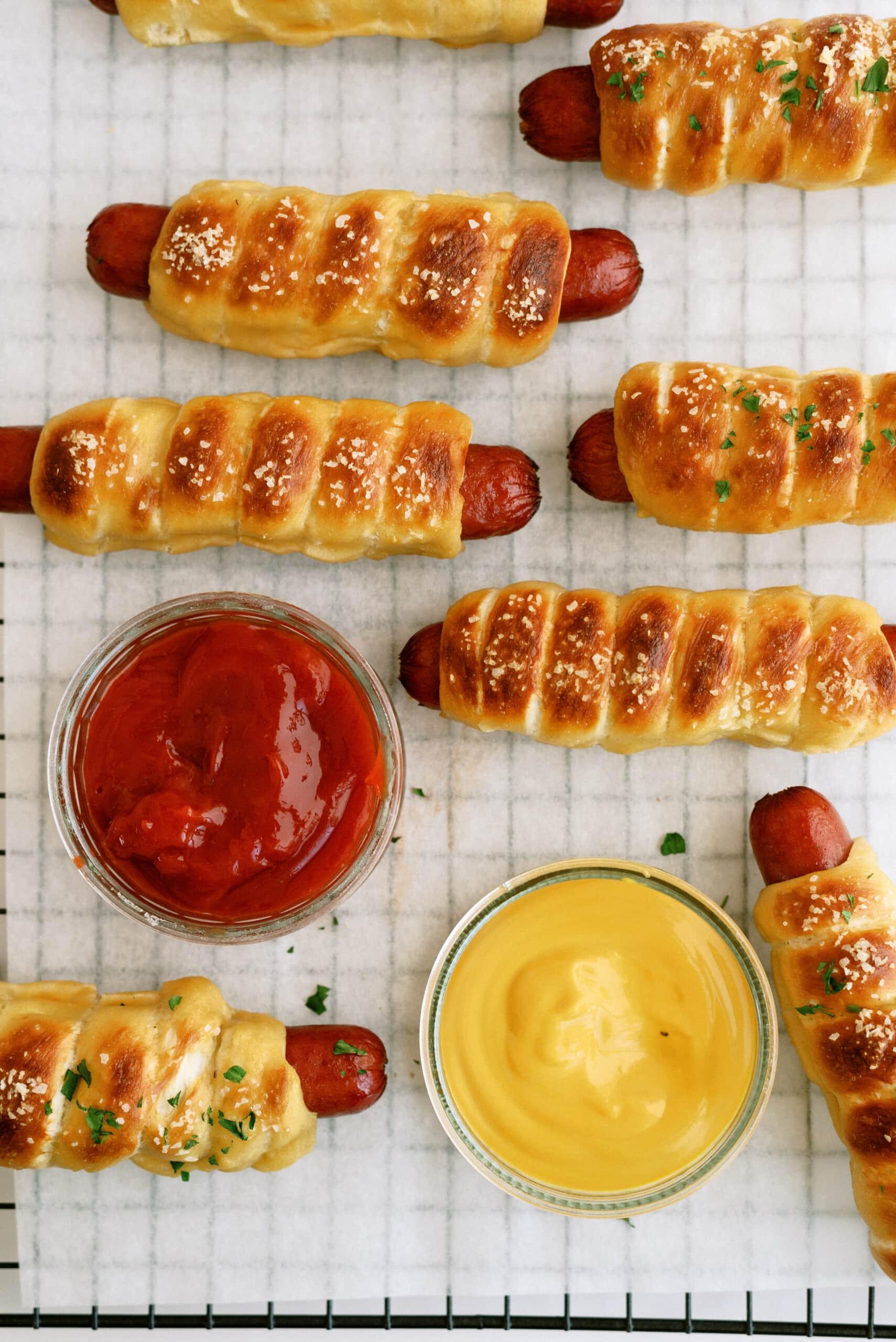 pretzel dogs on a cooling wrack with ketchup and mustard