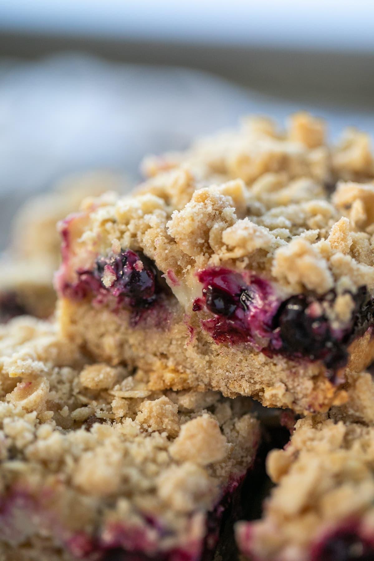 close up of a corner of a lemon blueberry bar stacked on top of other bars