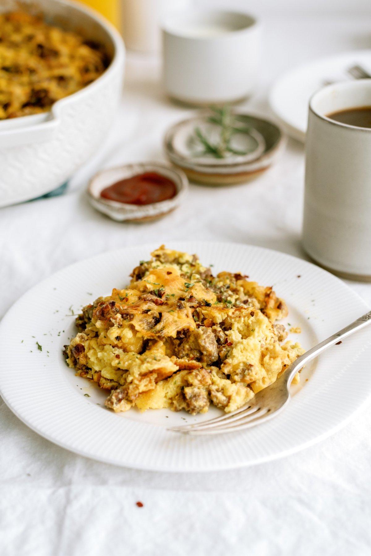 breakfast casserole on white plate with fork