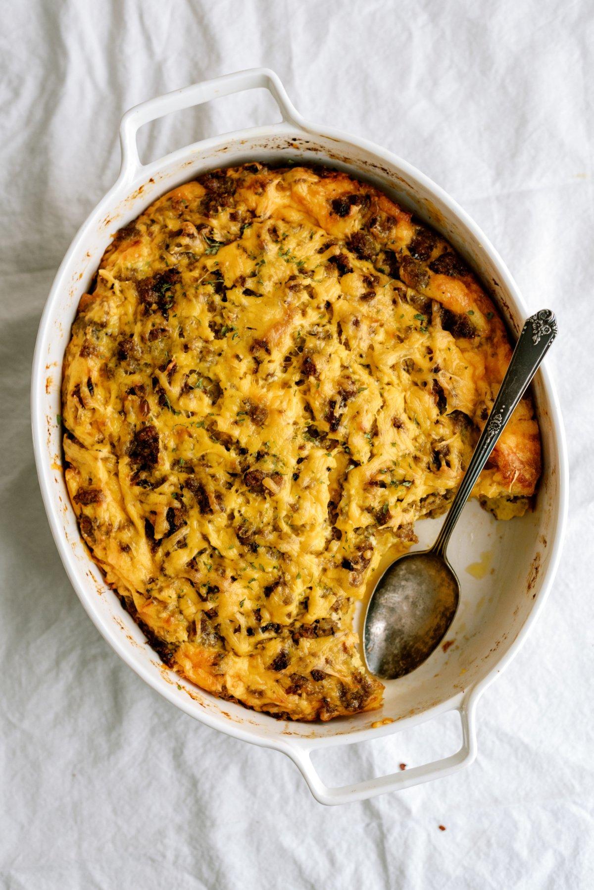 breakfast casserole in oval white dish with spoon