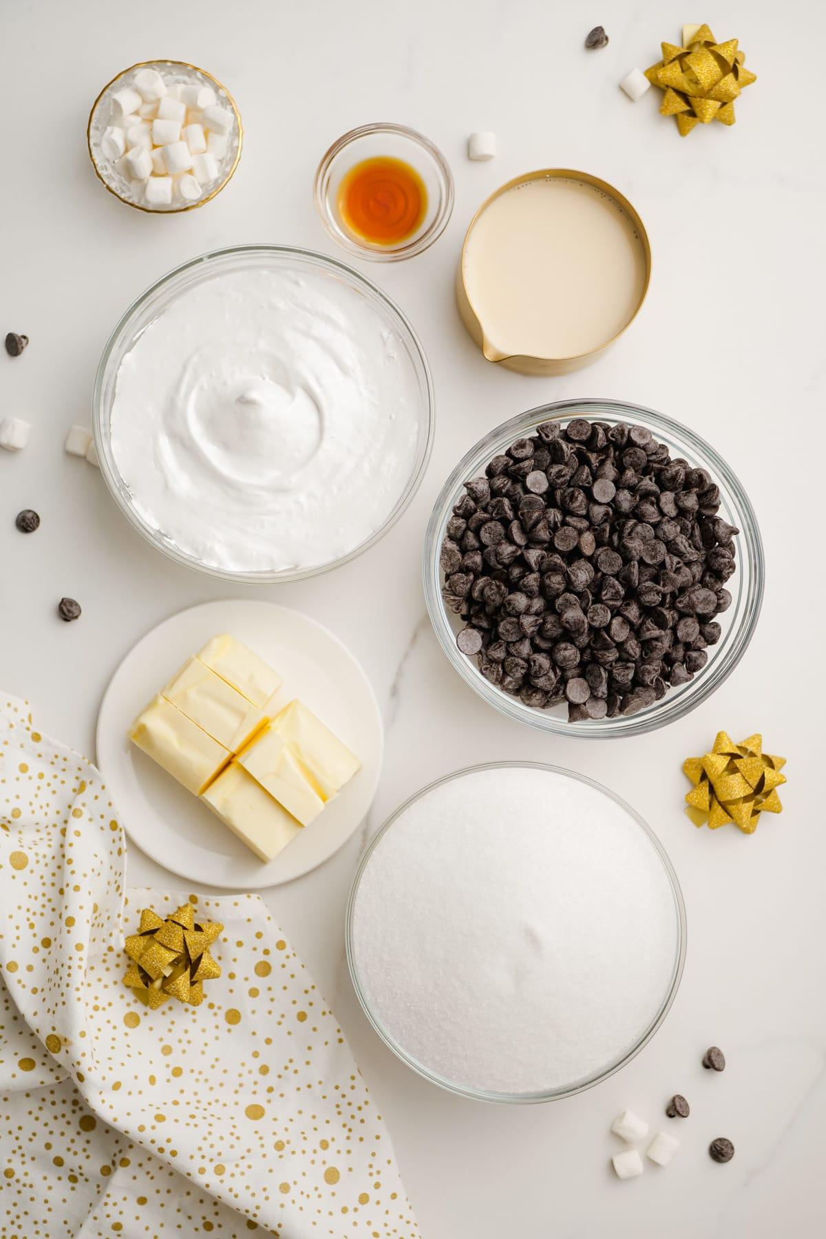 Sugar, butter, chocolate chips, marshmallows and evaporated milk in individual bowls