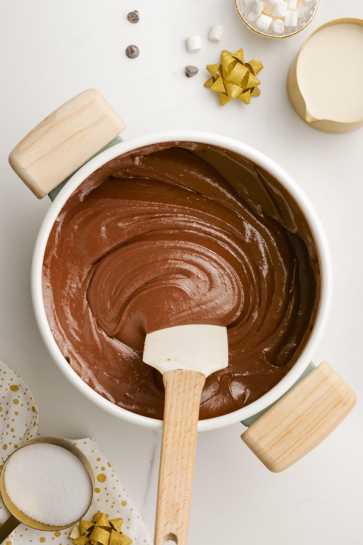 melted fudge in a pot with a rubber scraper stiring.