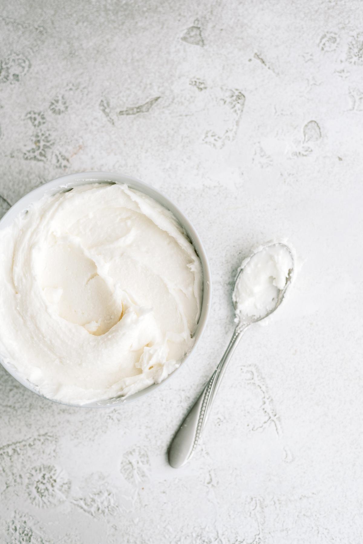 royal icing in bowl with spoon laying next to it