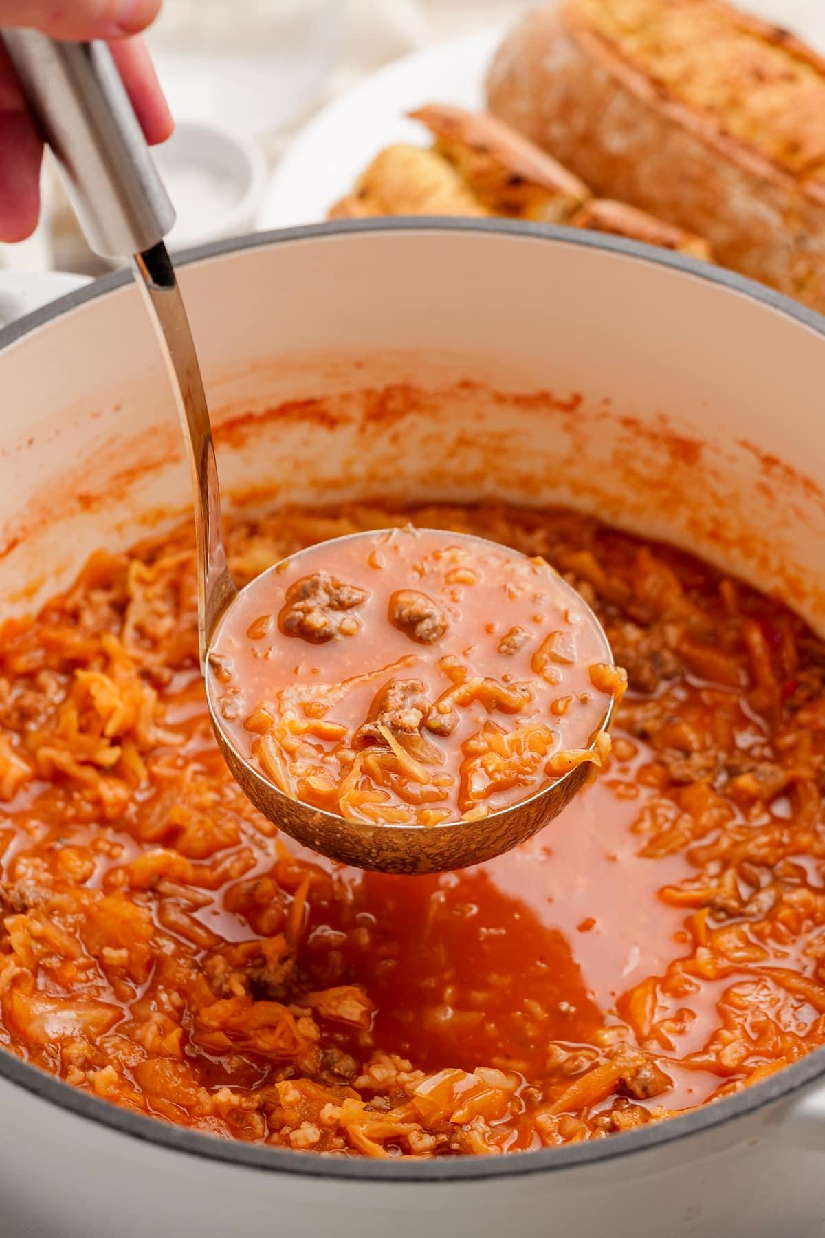 woman's hand ladeling out cabbage-roll-soup-in pot