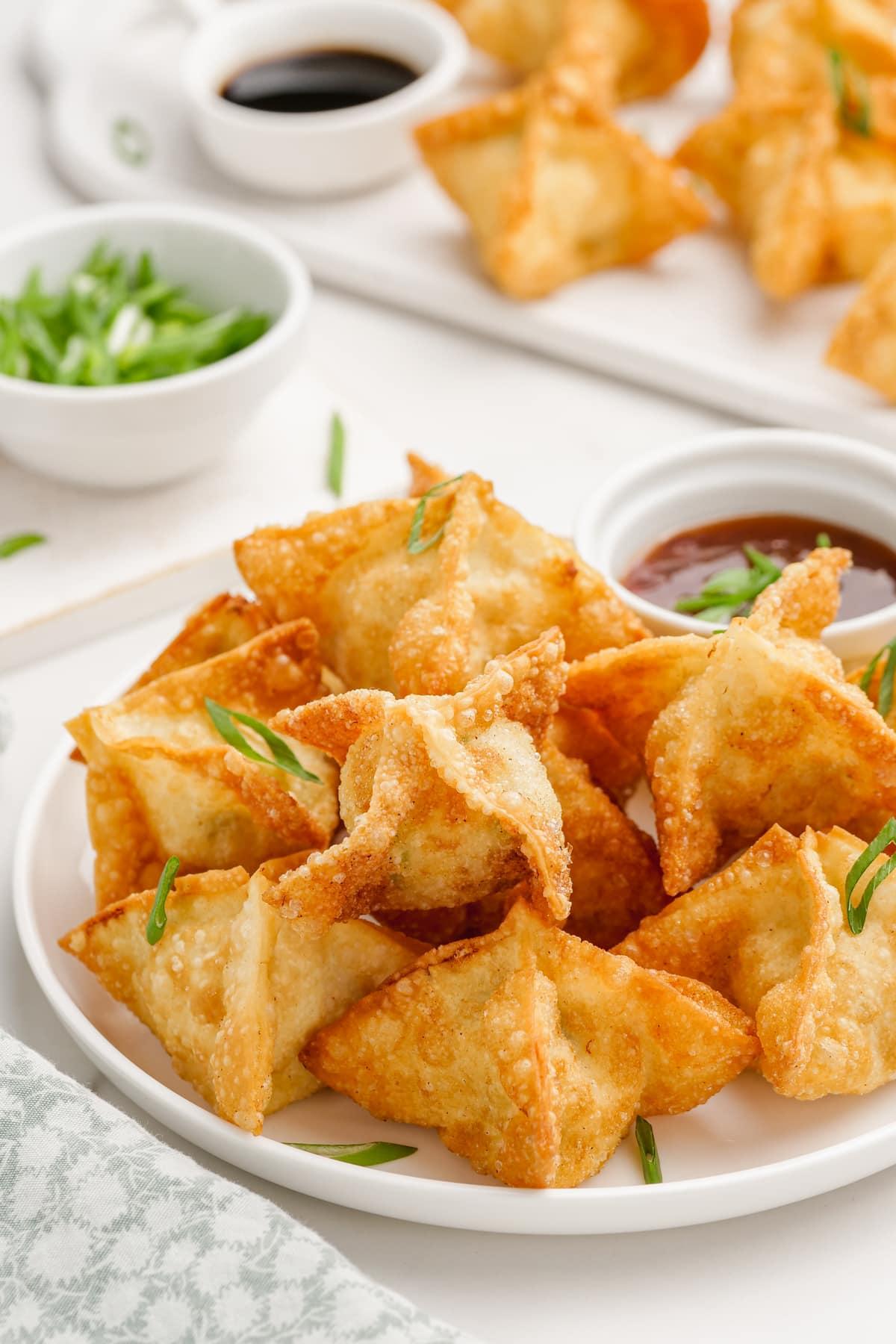 crab rangoon on a plate with dipping sauce