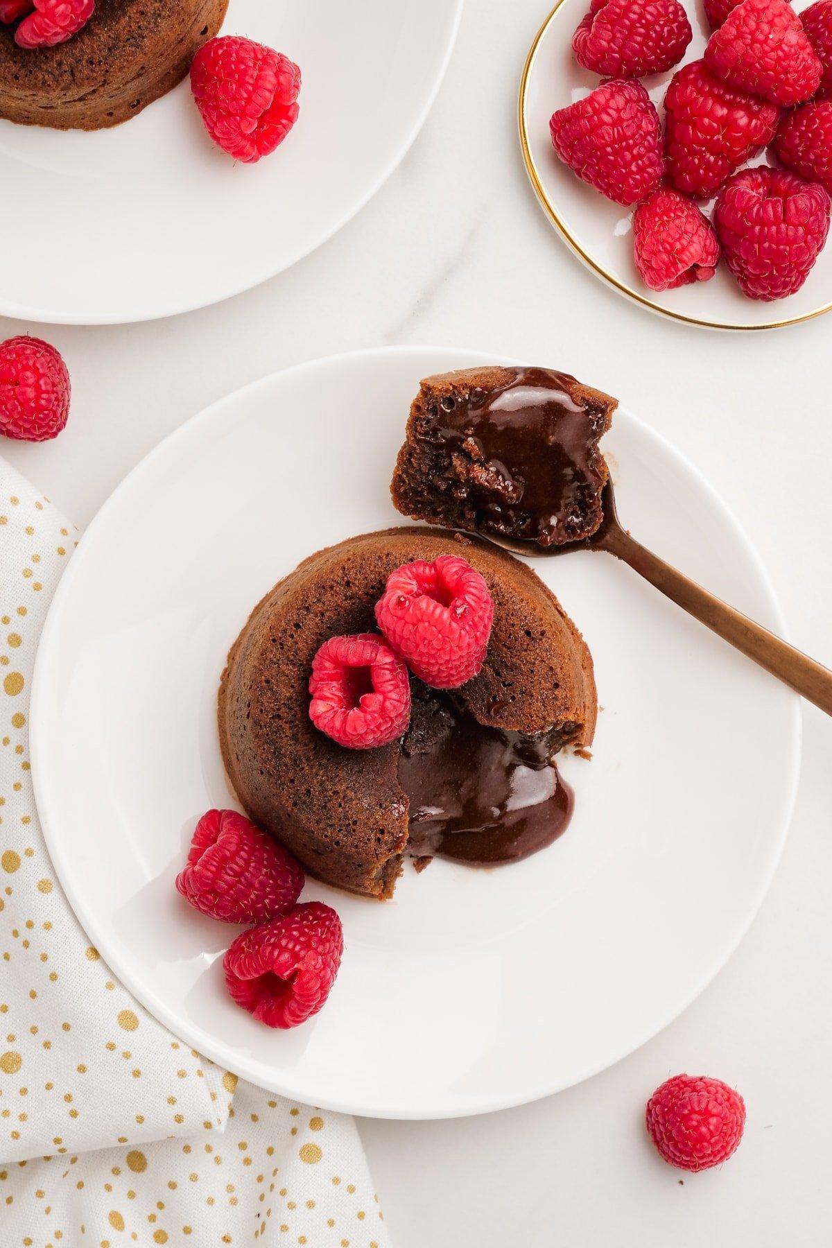 molten-lava-cake with raspberries on plates with spooned out filling